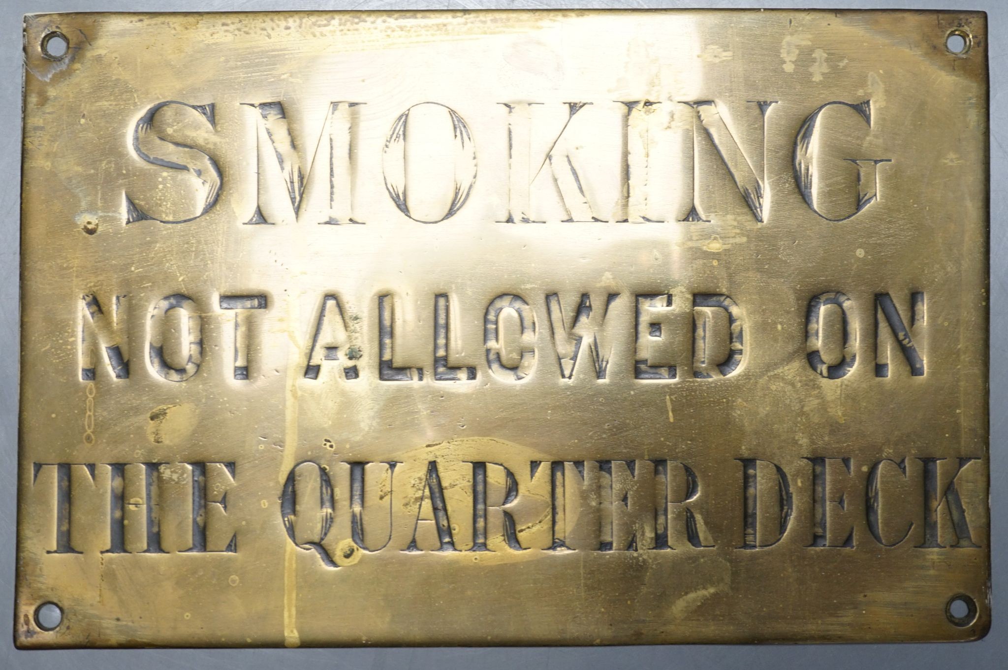 A brass plaque 'Smoking not allowed on the quarter deck’ 16.5x25cm